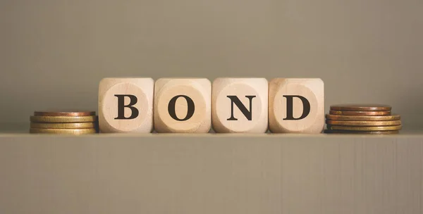 Palabra Bond Escrito Cubos Madera Monedas Sobre Fondo Gris Estudio —  Fotos de Stock