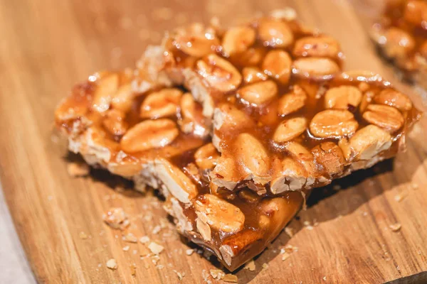 Sweet peanut brittle on a wooden board.