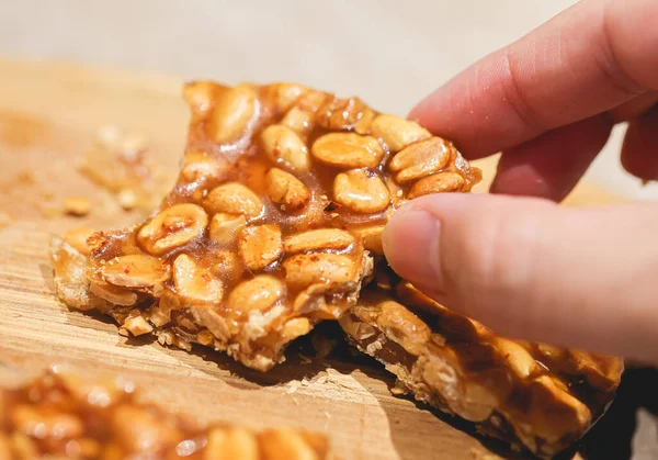 close-up of person holding sweet peanut brittle