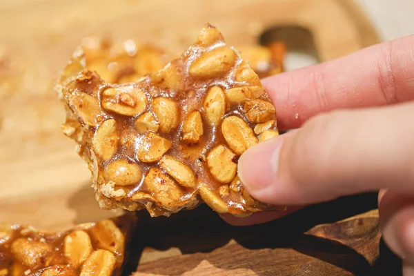 close-up of person holding sweet peanut brittle