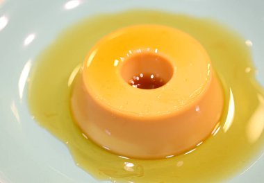 Yeşil bir tatlı tabağında servis edilen küçük bir muhallebi. Portekizce 'de Pudim de leite kondensado denilen Brezilya tatlısı.. 