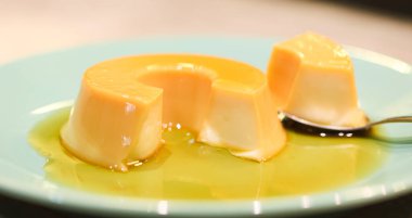 Yeşil bir tatlı tabağında servis edilen küçük bir muhallebi. Portekizce 'de Pudim de leite kondensado denilen Brezilya tatlısı.. 