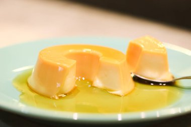 Yeşil bir tatlı tabağında servis edilen küçük bir muhallebi. Portekizce 'de Pudim de leite kondensado denilen Brezilya tatlısı.. 