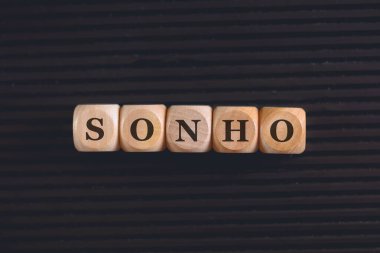 Brezilya Portekizcesi 'nde tahtadan küplere yazılmış DREAM yazıtı. Siyah arkaplan. 