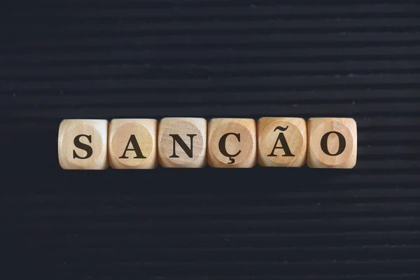 Napis Sanction Języku Brazylijskim Napisany Drewnianych Kostkach Czarne Tło — Zdjęcie stockowe