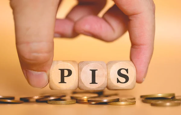 stock image Close-up view of man forming acronym PIS written on wooden cubes. Studio photo. 