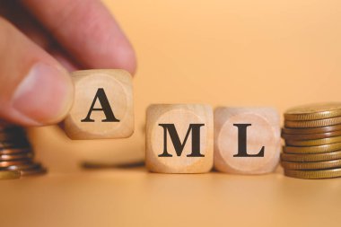 Ahşap küplere yazılmış Anti-Para Aklama için AML kısaltması oluşturan insanın yakın plan görüntüsü. Stüdyo fotoğrafı. 