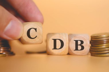 Brezilya Portekizce tahtadan küplere yazılmış banka mevduat sertifikası için CDB kısaltması oluşturan adamın yakın plan görüntüsü. Stüdyo fotoğrafı. 