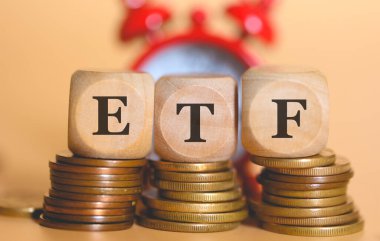 ETF Ticaret Fonu kısaltması. Tahta küplere ve bozuk para yığınlarına yazılmış. Stüdyo fotoğrafı.