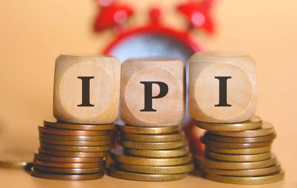 stock image Acronym IPI written on wooden cubes and piles of coins. Studio photo.