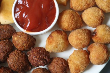 Makro shot 'lı ketçaplı sos tutacağı olan bir tabakta çeşitli Brezilya atıştırmalıkları.. 