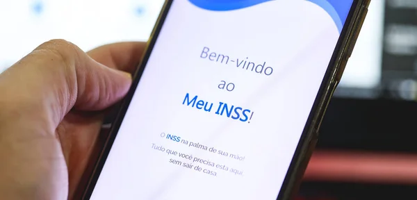 stock image Brasilia, Federal District, Brazil - April, 2023. Cell phone with the INSS logo on the screen. National Institute of Social Security in Brazilian Portuguese. 