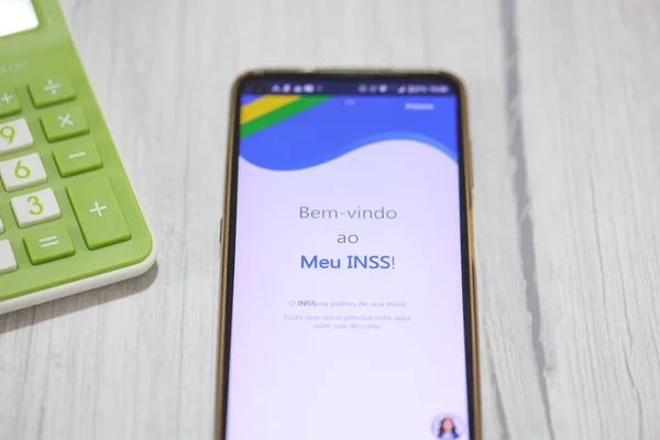 stock image Brasilia, Federal District, Brazil - April, 2023. Cell phone with the INSS logo on the screen. National Institute of Social Security in Brazilian Portuguese. 