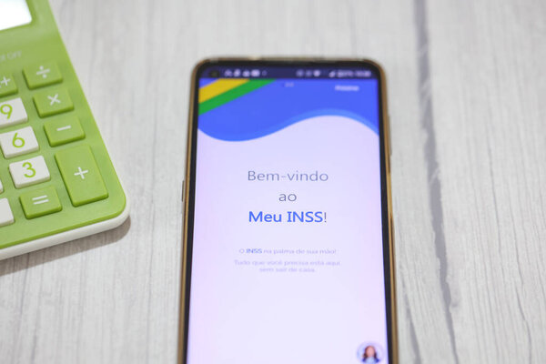 Brasilia, Federal District, Brazil - April, 2023. Cell phone with the INSS logo on the screen. National Institute of Social Security in Brazilian Portuguese. 