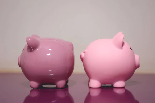 stock image Close-up view of two piggy banks on piece of furniture. Finance concept.