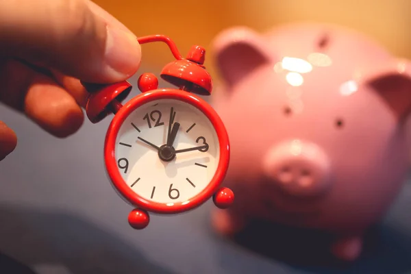 stock image Close-up view of piggy bank and alarm clock. Finance and time concepts.