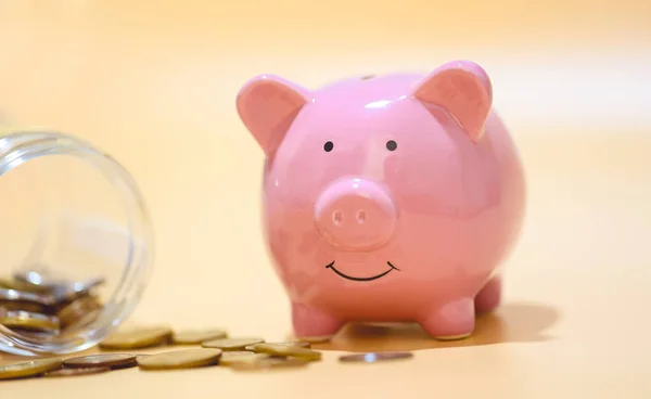 Stock image Close-up view of pink piggy bank and coins. Finance concept.