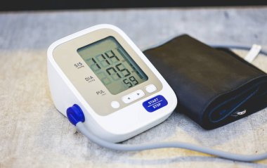 Tahta masa arkasında elektronik tansiyon monitörü.