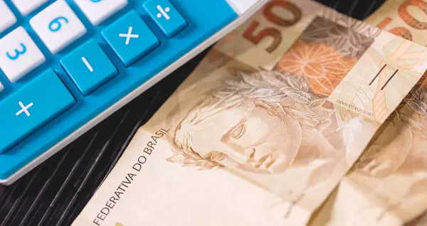Brazilian Real notes on a calculator. Brazilian economy, finance and income tax.