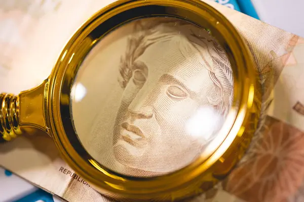 stock image Close-up view of Brazilian Real Banknote under magnifying glass. Brazilian economy.