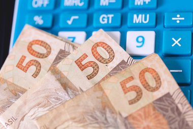 Bir hesap makinesine gerçek Brezilya notları. Brezilya ekonomisi, finans ve gelir vergisi.