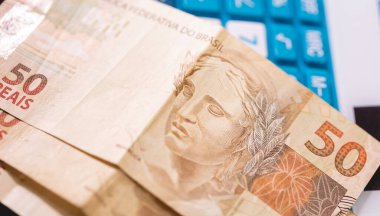 Bir hesap makinesine gerçek Brezilya notları. Brezilya ekonomisi, finans ve gelir vergisi.