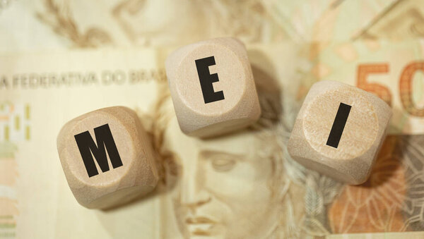 Аббревиатура MEI для индивидуального микропредпринимателя, написанная на деревянных костях на бразильском португальском языке. 50 бразильских реальных банкнот в составе.