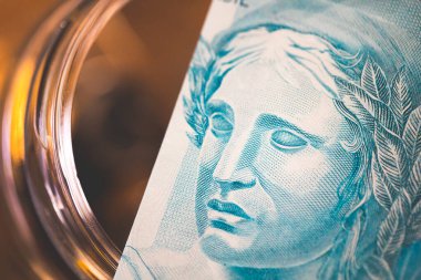 Brezilya usulü 100 reais 'lik banknotlar cam kavanozdaki domuz kumbarası. Finans ve yatırımlar.