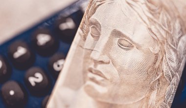 Hesap makinesi ve Brezilya Real banknotunun yakın plan çekimi. Finans ve Brezilya ekonomisi.