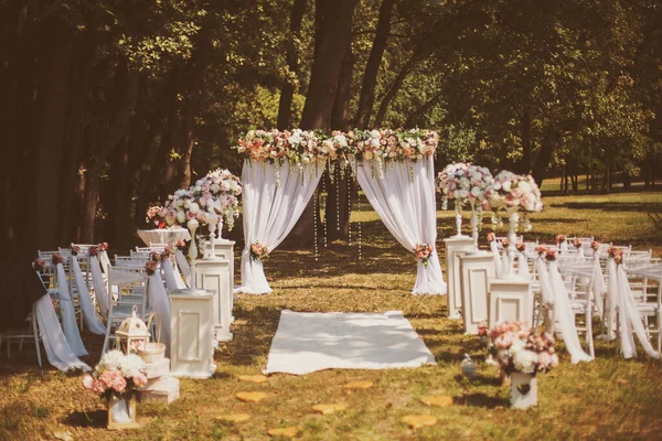 外面装饰着鲜花的婚礼 结婚仪式 装饰着粉色和白色的花朵屹立在树林里 在婚礼的区域 在一个漂亮的婚礼上给客人让座 — 图库照片