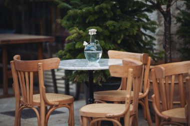 Avrupai yaya caddesinde teras verandası süslemesi, sandalyeler, masa suyu. Avrupa 'da masa ve sandalyeli bir kahve terası manzarası.