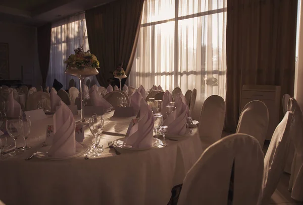 結婚式 宴会だ 椅子とお客様のための丸いテーブルは カトラリー 花や食器で提供し テーブルクロスで覆われています パステル調の色合いで古典的な結婚式のためのスタイリッシュな結婚式の装飾 — ストック写真