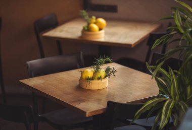 Tahta bir masanın üzerinde yaprakları olan limonlar. İtalya 'daki açık hava restoranı. Yemek, seyahat ve tatil konsepti. Lokantaya hazırlanıyorum. Monterosso 'da küçük bir teras, Cinque Terre..
