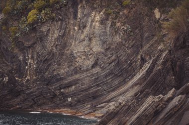 Dağ taşı deseni ve dokusu. Kaba kaya oluşumunun düz olmayan yüzeyinin dokulu arkaplanı. Dolomitlerin minimalist manzarası Liguria, İtalya 'nın tipik taş dokusuna sahiptir..