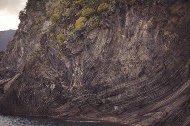 Dağ taşı deseni ve dokusu. Kaba kaya oluşumunun düz olmayan yüzeyinin dokulu arkaplanı. Dolomitlerin minimalist manzarası Liguria, İtalya 'nın tipik taş dokusuna sahiptir..