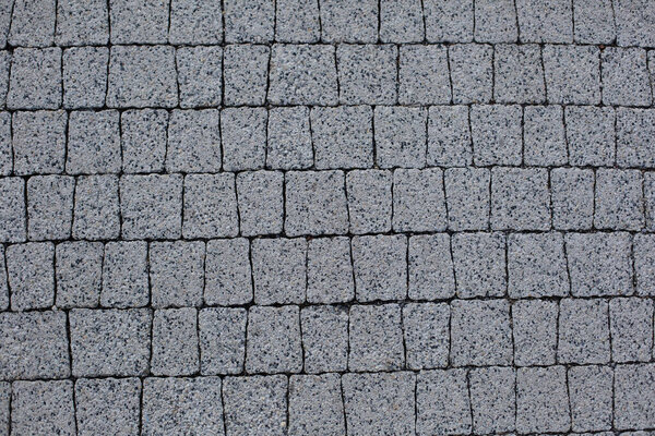 Abstract background. Old cobblestone pavement close-up. Square Texture Pattern. granite pavement. Stone texture for the facade.