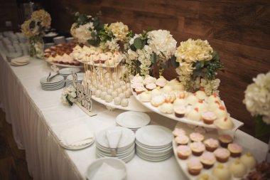 Delicious sweet buffet with cupcakes. Sweet holiday buffet with cupcakes and other desserts. Candy Bar. Dessert table for party goodies. Party reception, decorated delicious in the restaurant.