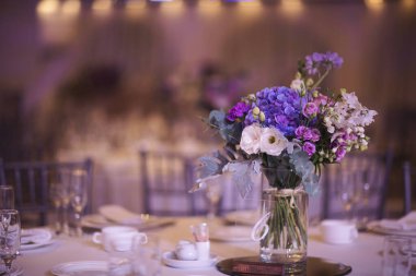 Düğün masalarının güzel çiçek süslemesi. Ziyafet masası ve dekorasyon. Masada çatal bıçak takımı var. Etkinlik partisi için masalar hazır. Lüks, zarif bir masa, bir restoranda yemek hazırlıyor..