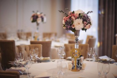 Düğün masalarının güzel çiçek süslemesi. Ziyafet masası ve dekorasyon. Masada çatal bıçak takımı var. Etkinlik partisi için masalar hazır. Lüks, zarif bir masa, bir restoranda yemek hazırlıyor..