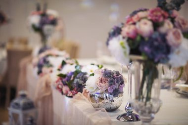 Düğün masalarının güzel çiçek süslemesi. Ziyafet masası ve dekorasyon. Masada çatal bıçak takımı var. Etkinlik partisi için masalar hazır. Lüks, zarif bir masa, bir restoranda yemek hazırlıyor..