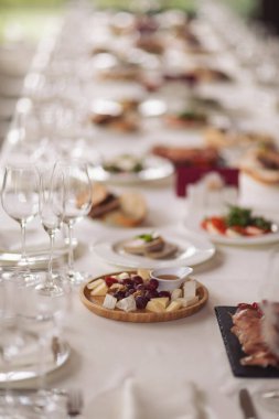 Yemek servisi. Yemekli restoran masası. Masada büyük miktarda yiyecek var. Tabaklar dolusu yemek. Yemek vakti, öğle yemeği. Farklı mezeler, meze, şarküteri, atıştırmalık, peynir, salata, börek..