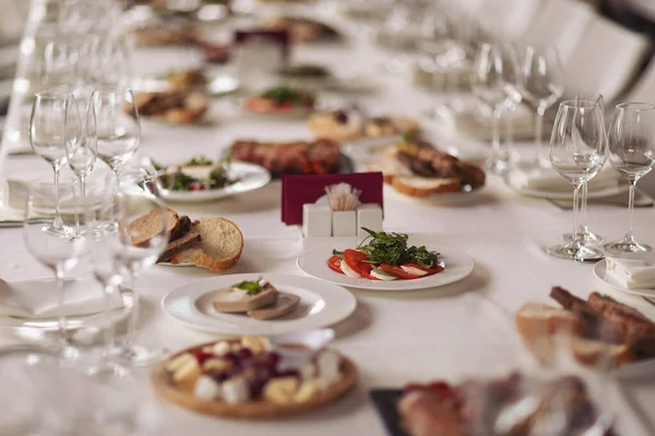 Yemek servisi. Yemekli restoran masası. Masada büyük miktarda yiyecek var. Tabaklar dolusu yemek. Yemek vakti, öğle yemeği. Farklı mezeler, meze, şarküteri, atıştırmalık, peynir, salata, börek..