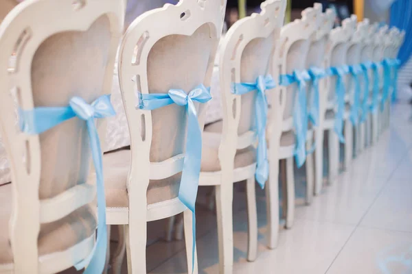 wedding chairs and details on summer wedding. ceremony decorations in restaurant. Elegant decoration of wedding ceremony outdoor. Wedding banquet with beautiful white furniture.