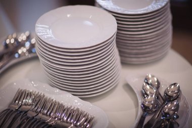 Zarif bir sofra. Çanak çömlek, mutfak. Bir grup metal kaşık tepside, bir restoran yan durağı. Açık büfe yemeği için mükemmel porselen tabaklar. Parti için beyaz tabak takımı..