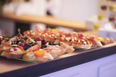 Tatil için atıştırmalıklar, yemek servisi. Çeşitli hafif atıştırmalıklar. Yemek tabağı. Büfe masasında bir sürü sandviç var. Et, balık, fındık, peynir, önemli olayın sebze kanepeleri. 