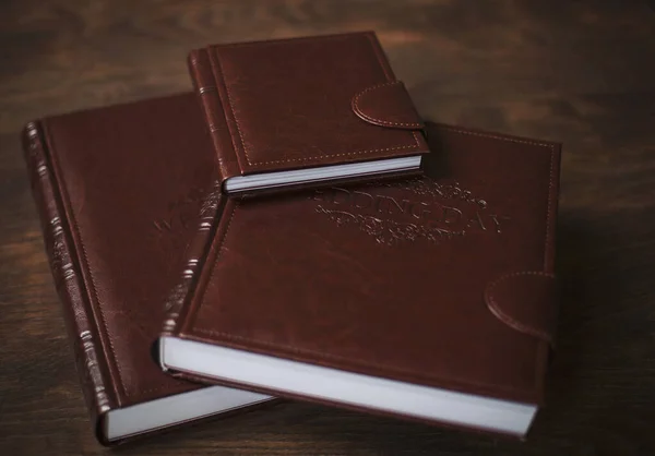 Wedding photobooks in brown leather binding. Wedding photo book, album family album. Photo books with embossing and a cover of genuine leather. Services of a professional photographer and designer.
