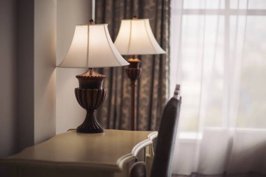 Yatak odasındaki ahşap masanın üzerinde modern yatak odası iç dekorasyonu ev mimarisi konsepti için güzel oturma odası dekorasyonu. Odadaki ya da oteldeki masa lambası.