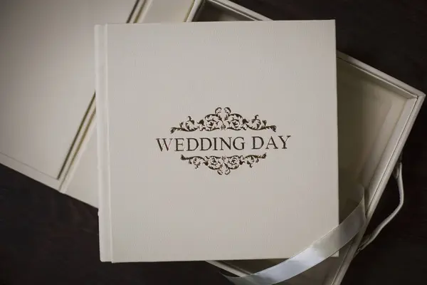 結婚式のアルバムのための正方形の写真集を保持する女性の手 結婚式の写真集家族のアルバム エンボス加工と本革のカバー付きの写真集 高価な装丁の本 — ストック写真