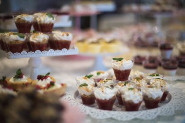 Taze çilek, ahududu ve nane yaprağıyla nefis bir pasta. Meyve ve böğürtlen dolu bir ziyafet masası ve bir sürü tatlı. Şeker çubuğu.