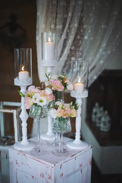 Wedding decor of the banquet table. Decoration flowers, decor candles, details closeup. Luxury romantic date. Location for surprise marriage proposal. Table setting in restaurant.
